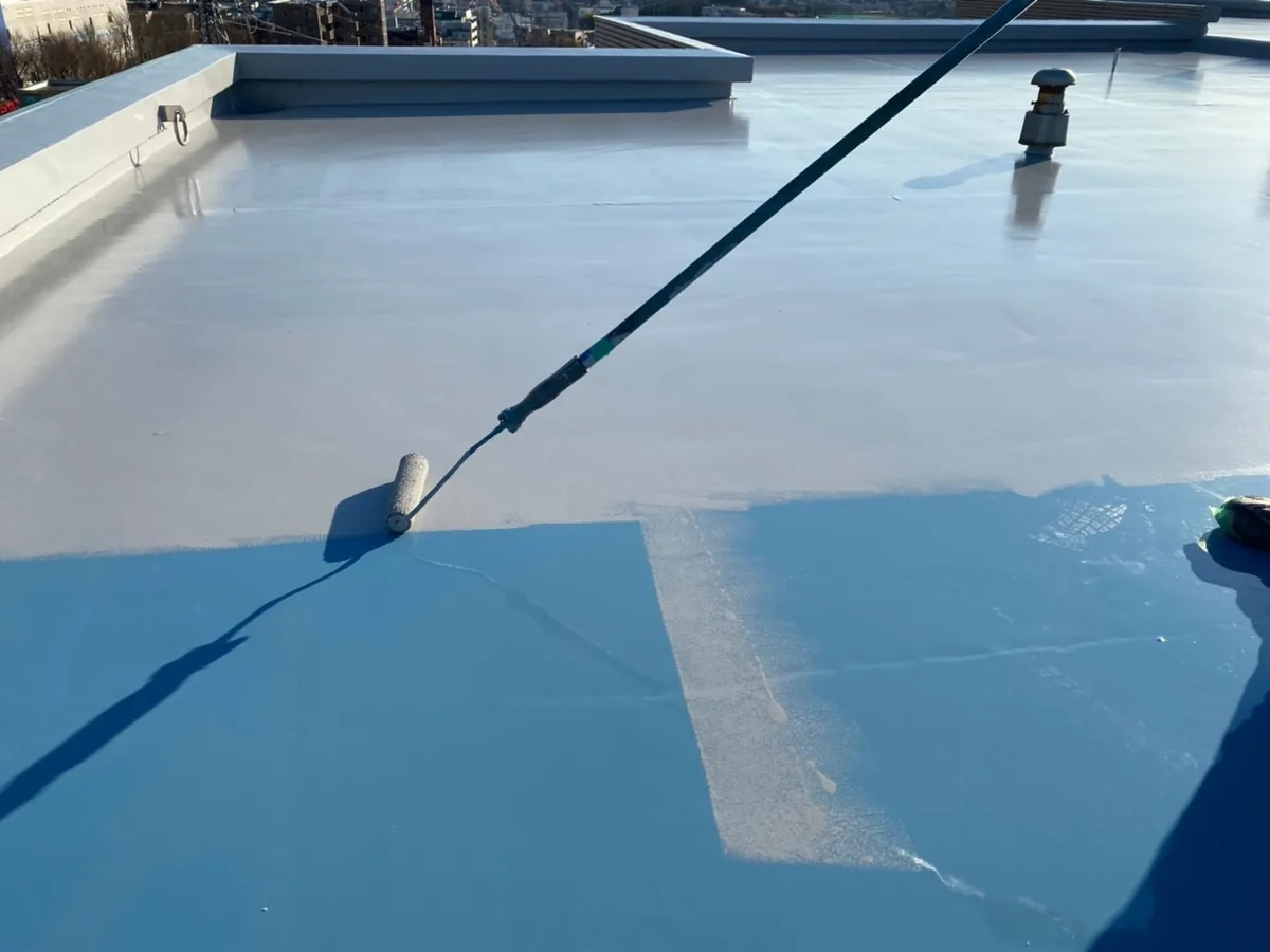 ローラーでウレタン防水材を塗り広げる作業