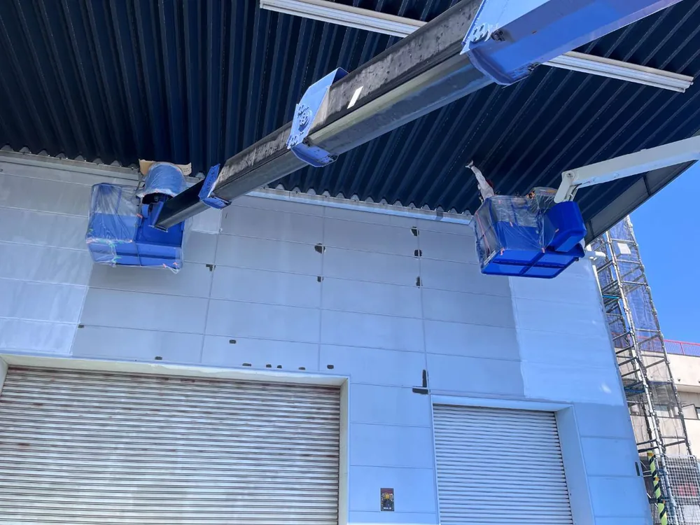 足立区の店舗建物。クレーン車を使った高所の塗装作業