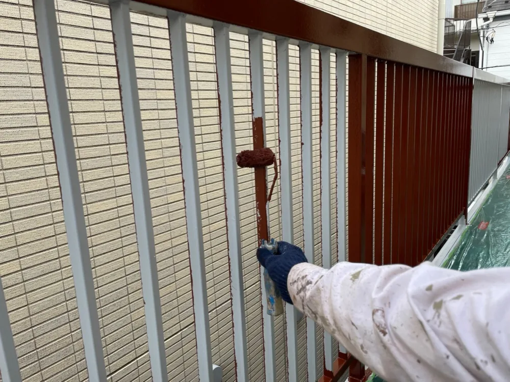 手すりの縦格子をローラーで塗る作業