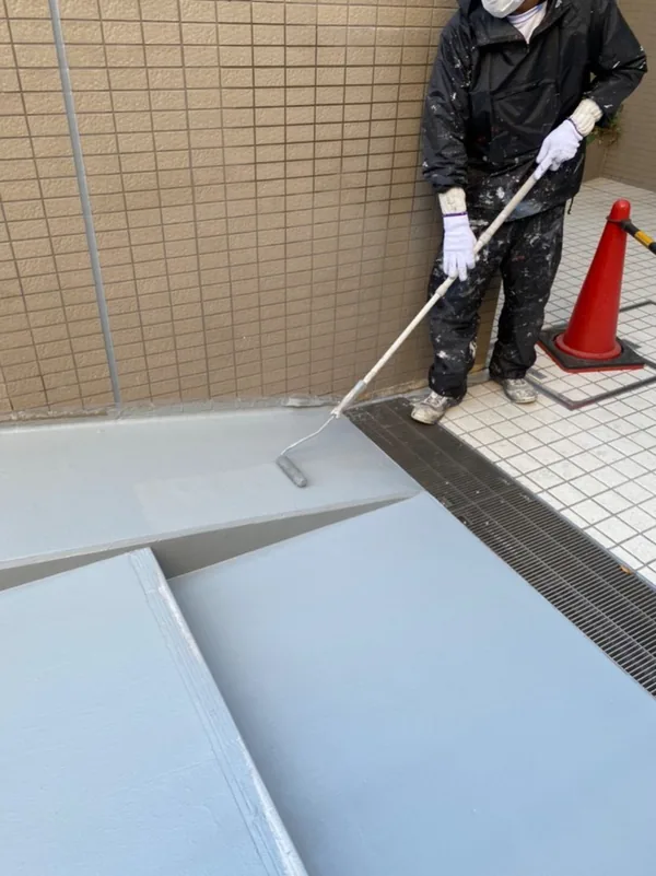 スロープの床をローラーで塗り広げる作業